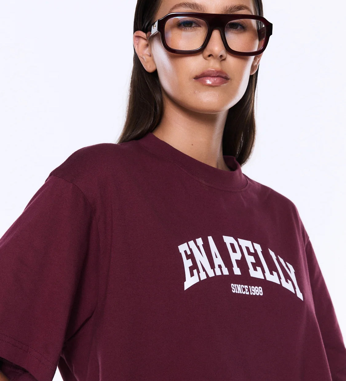 Person wearing a maroon t-shirt with 'ENAPELLY' branding on a white background