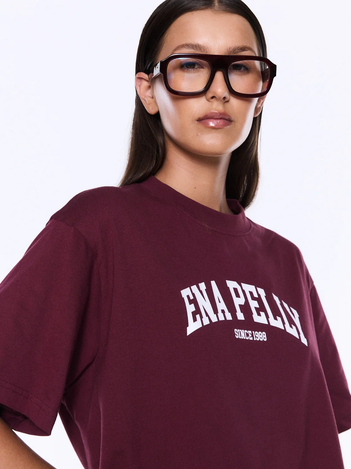 Person wearing a maroon t-shirt with 'ENAPELLY' branding on a white background