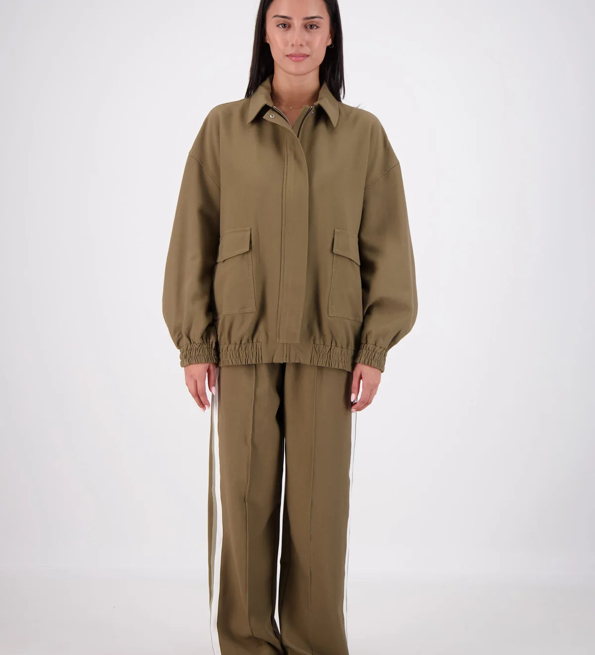 Person wearing a beige jumpsuit on a white background