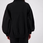 Person wearing a black jacket and pants on a white background