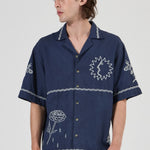 Person wearing a navy blue shirt with white patterns on a white background
