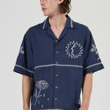 Person wearing a navy blue shirt with white patterns on a white background