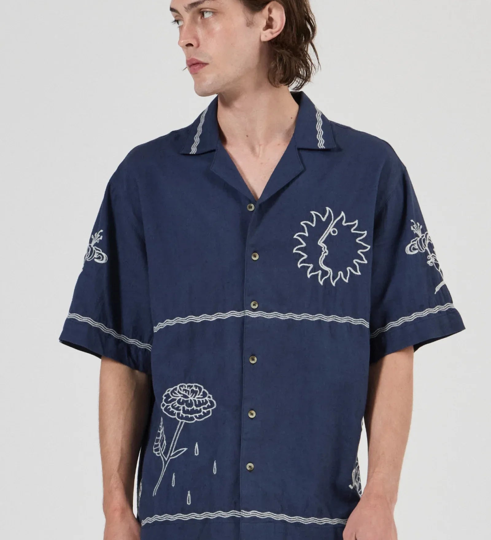 Person wearing a navy blue shirt with white patterns on a white background