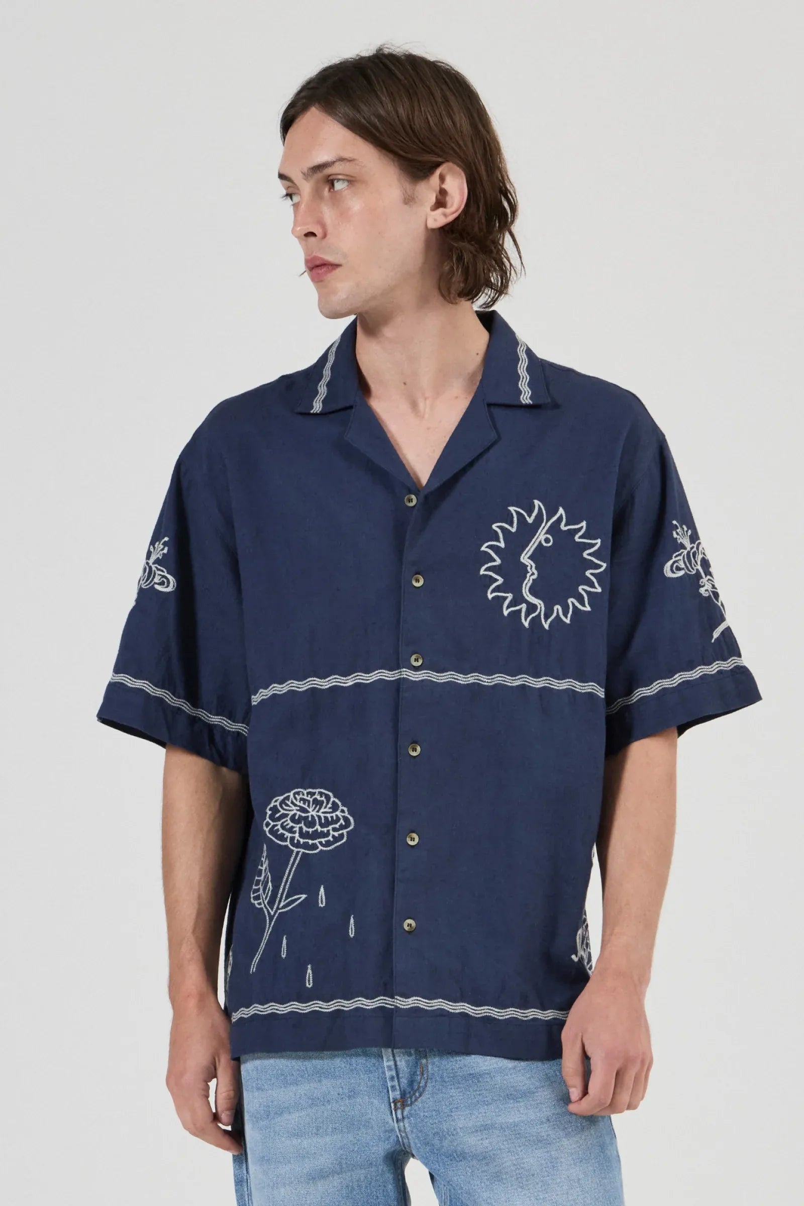 Person wearing a navy blue shirt with white patterns on a white background