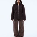 Person wearing a brown jacket and pants on a white background