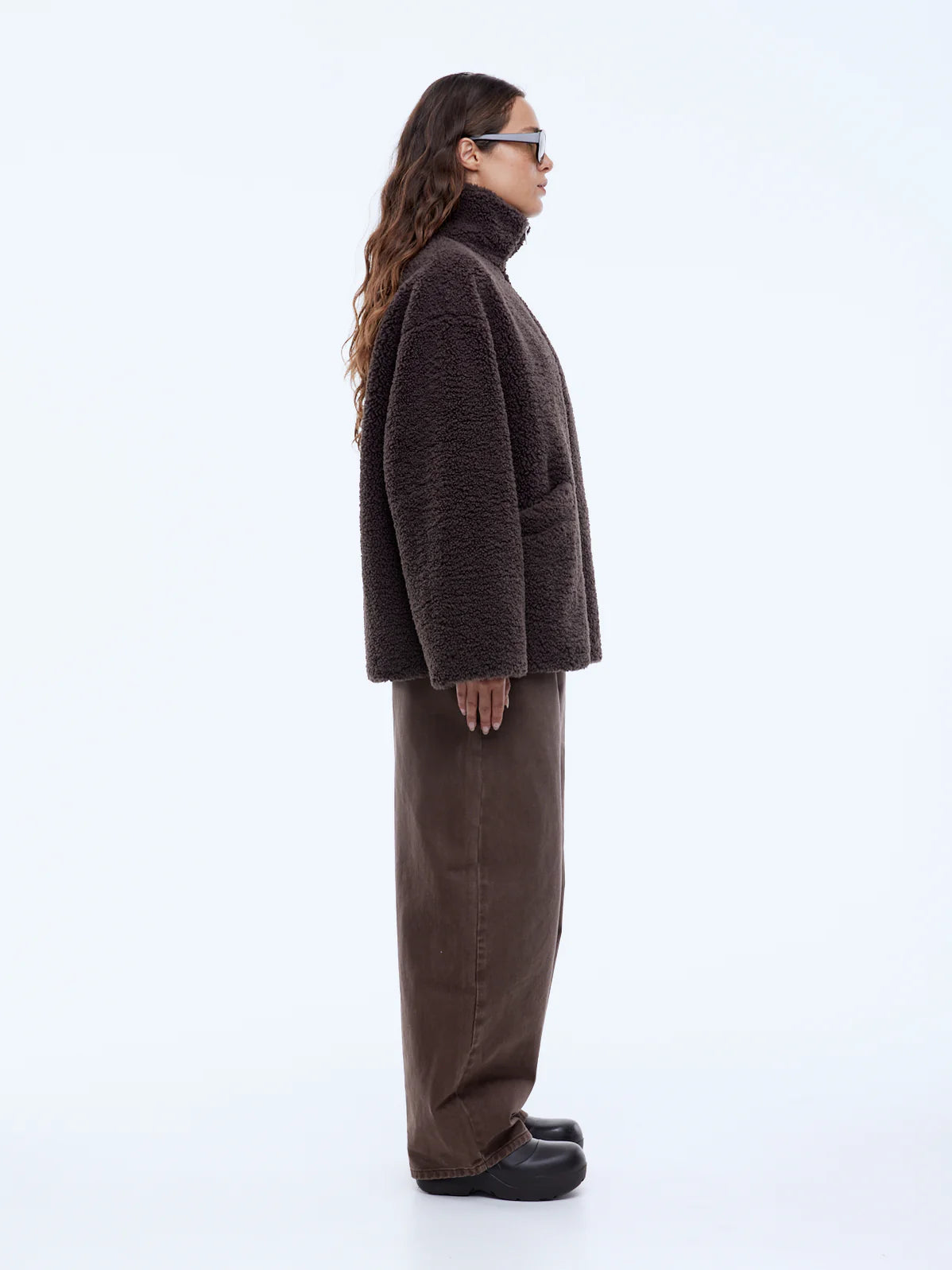 Person wearing a brown outfit on a white background