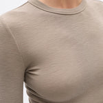 Close-up of a beige long-sleeve shirt on a plain background