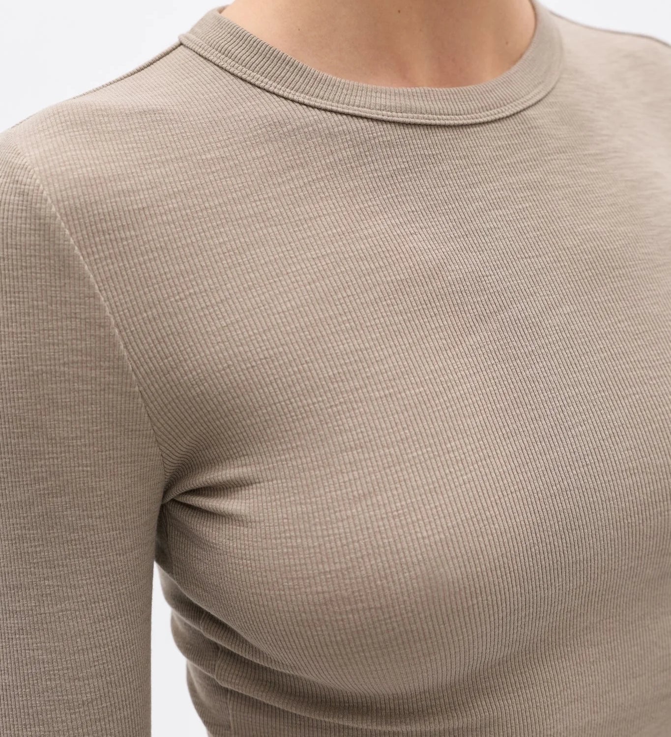Close-up of a beige long-sleeve shirt on a plain background