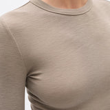 Close-up of a beige long-sleeve shirt on a plain background