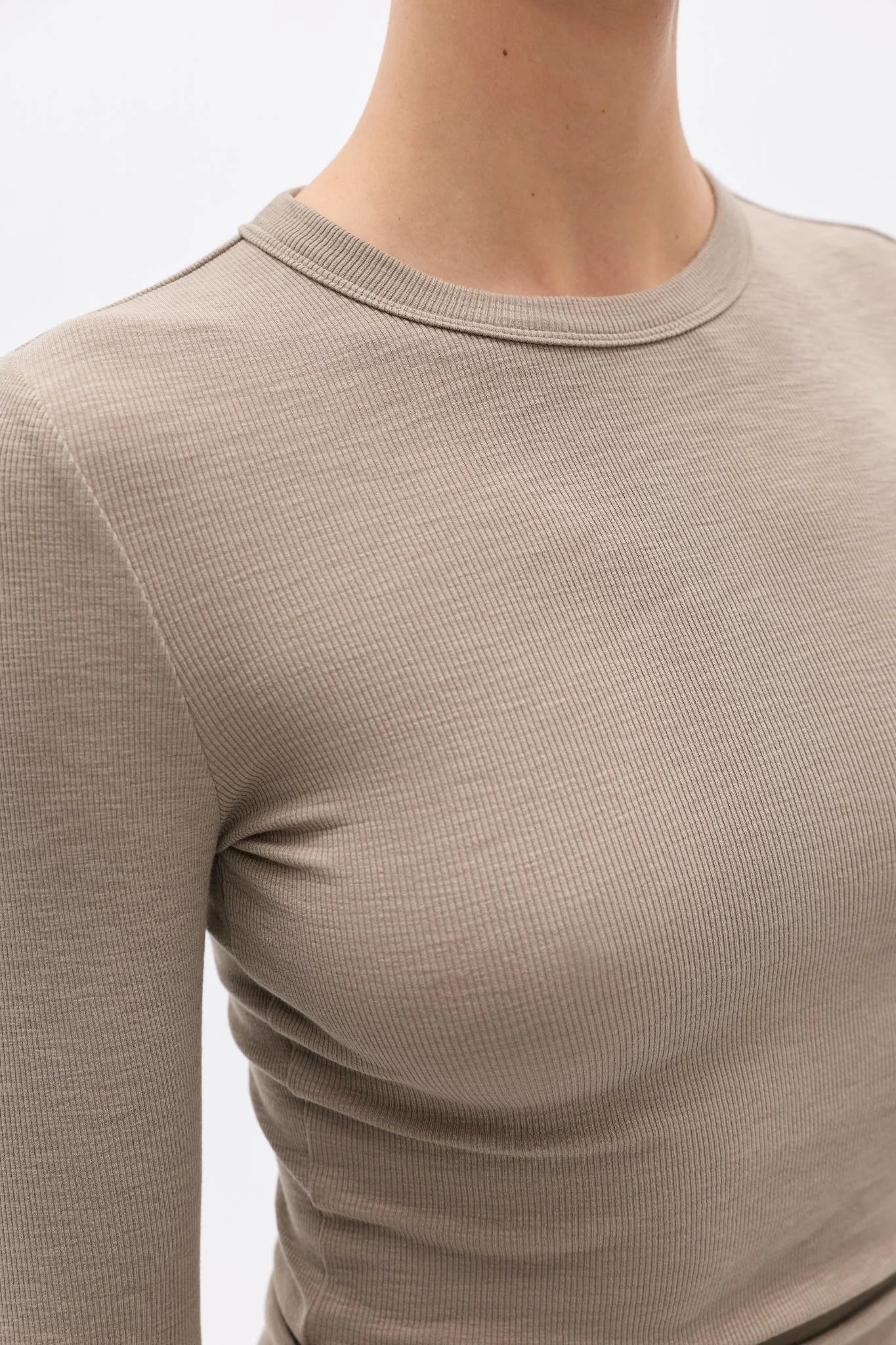 Close-up of a beige long-sleeve shirt on a plain background
