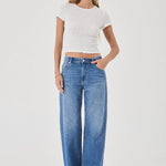 Woman wearing a white top and blue jeans on a white background