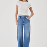 Woman wearing a white top and blue jeans on a white background