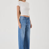 Woman wearing a white top and blue jeans on a white background