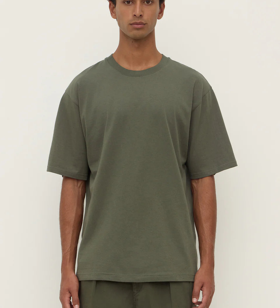 Person wearing a green t-shirt and pants against a white background