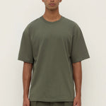 Person wearing a green t-shirt and pants against a white background