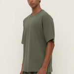 Man wearing a green t-shirt and pants against a white background