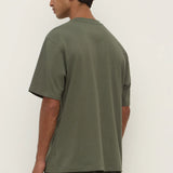 Person wearing a green t-shirt and pants against a white background