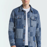 Man wearing a patchwork denim jacket on a white background