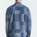 Man wearing a blue patchwork shirt on a white background