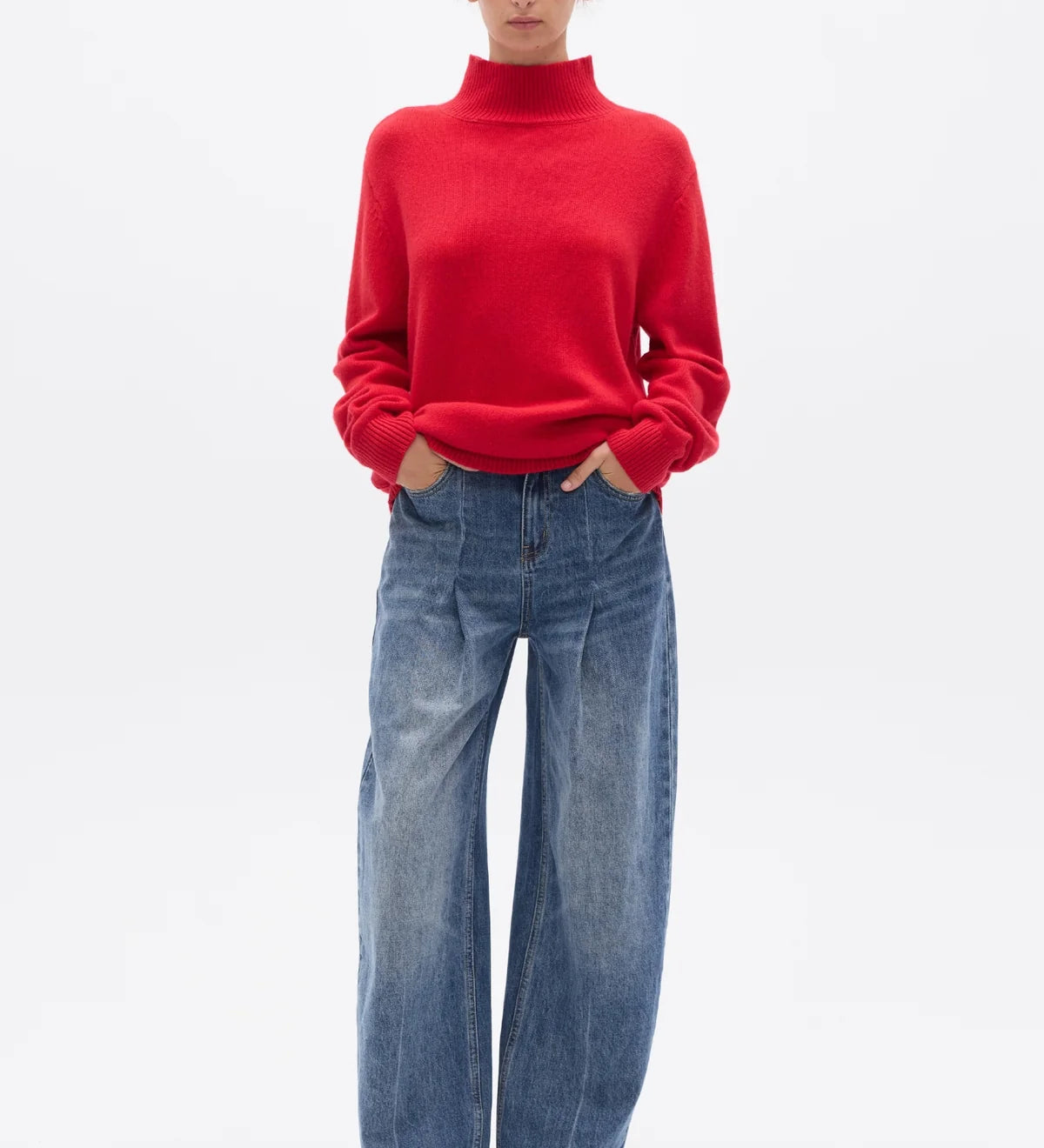 Person wearing a red sweater and blue jeans on a white background