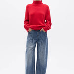 Person wearing a red sweater and blue jeans on a white background