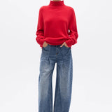 Person wearing a red sweater and blue jeans on a white background