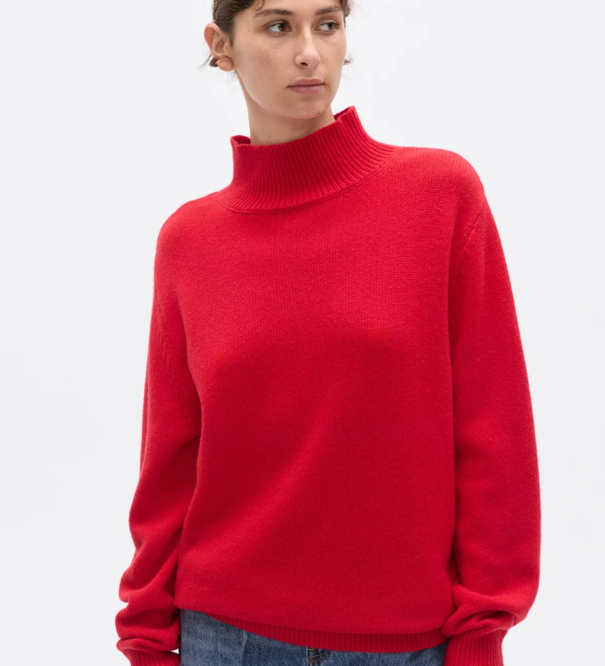 Person wearing a red turtleneck sweater on a white background
