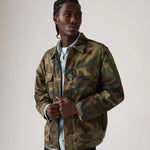 Man wearing a camouflage jacket against a plain background