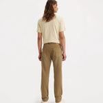 A model shown from the back wearing a light beige short-sleeve t-shirt and brown straight-leg jeans, standing against a plain white studio background.