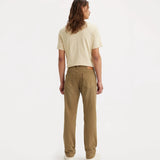 A model shown from the back wearing a light beige short-sleeve t-shirt and brown straight-leg jeans, standing against a plain white studio background.