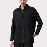 Woman wearing a black tencel shirt with product details on a white background