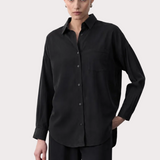 Woman wearing a black tencel shirt with product details on a white background