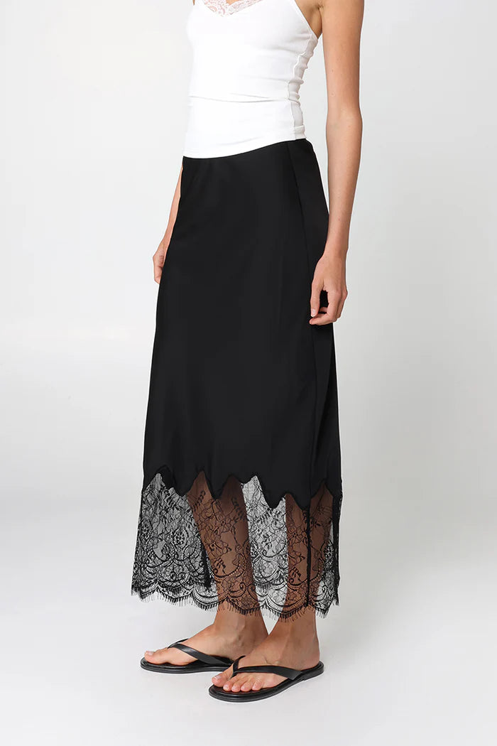 Black skirt with lace hem worn by a person on a white background