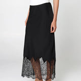 Black skirt with lace hem worn by a person on a white background