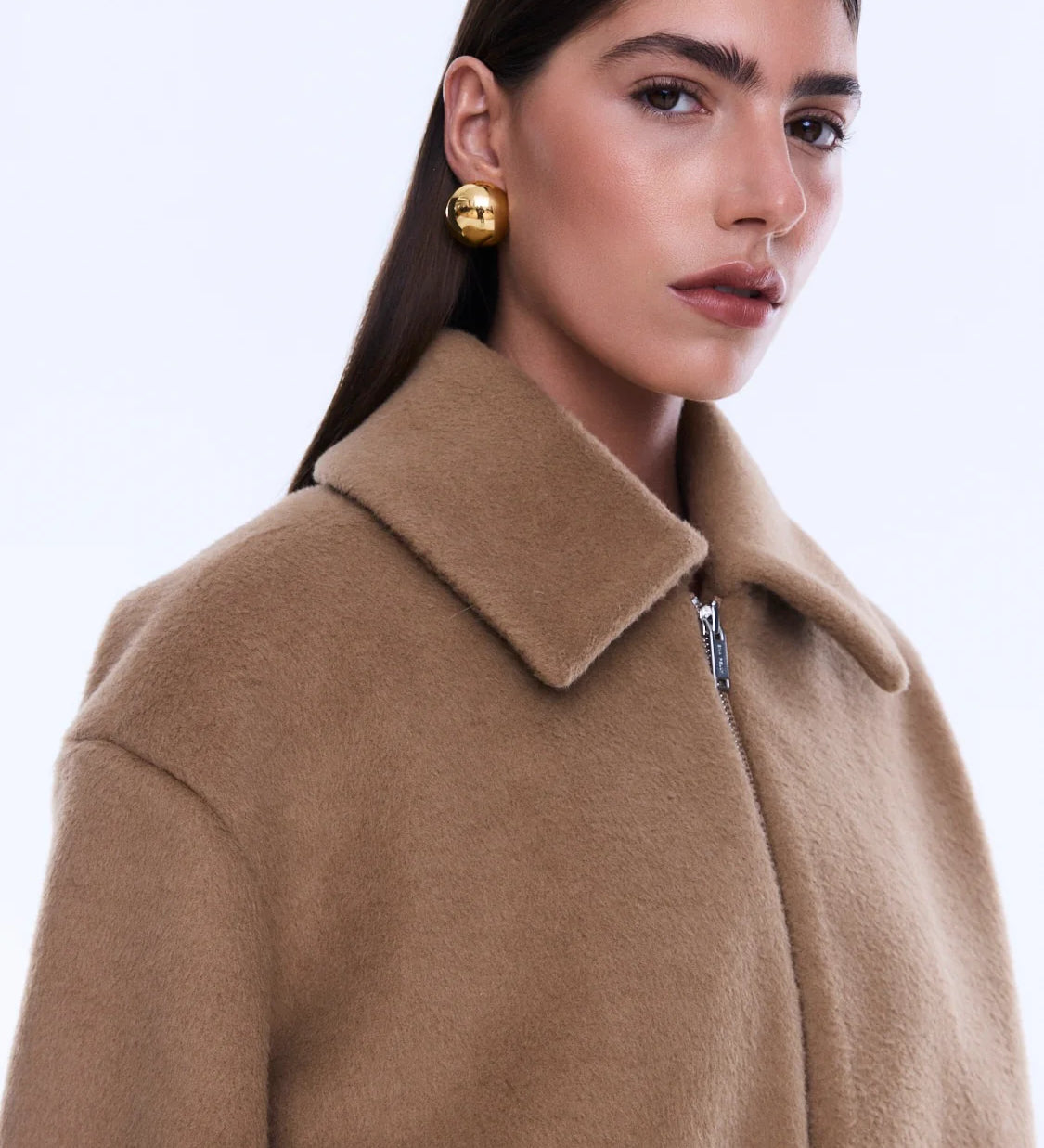 Woman wearing a beige coat on a white background