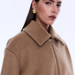 Woman wearing a beige coat on a white background