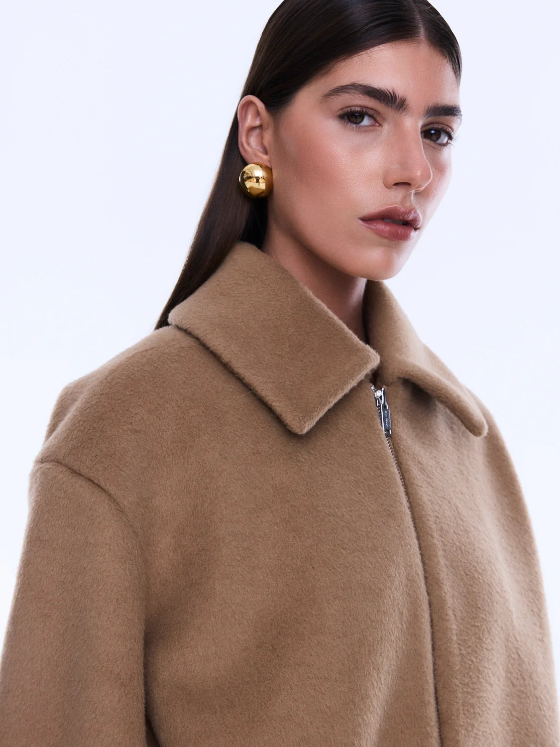 Woman wearing a beige coat on a white background
