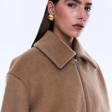 Woman wearing a beige coat on a white background