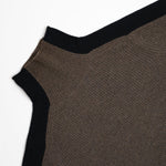 Close-up of a ribbed knit garment corner showing a dark brown body with black ribbed trim on a plain white background.