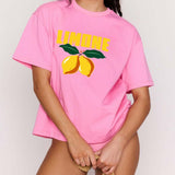Woman wearing a pink t-shirt with lemon graphics and 'Limon' text on a plain background