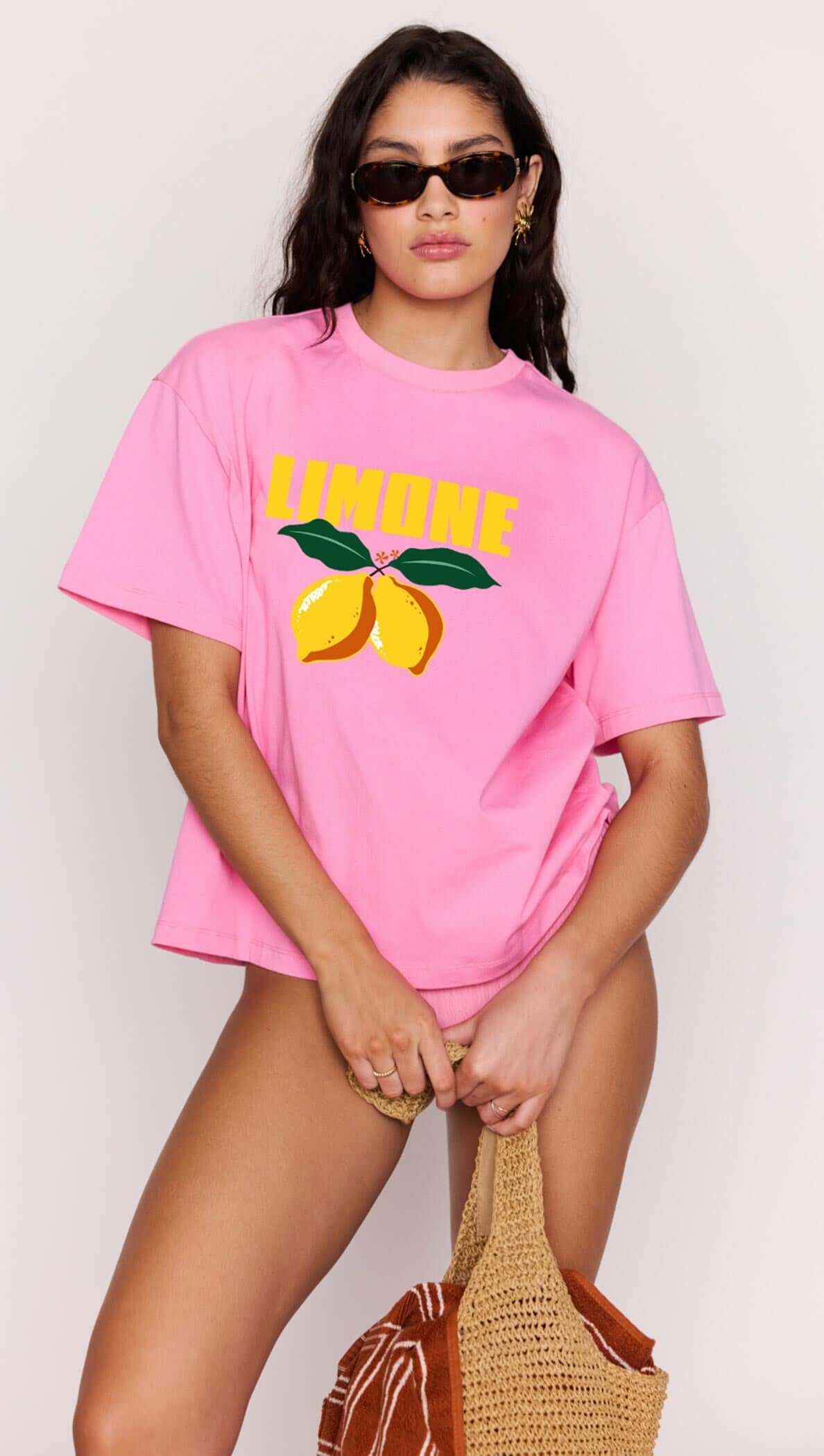 Woman wearing a pink t-shirt with lemon graphics and 'Limon' text on a plain background