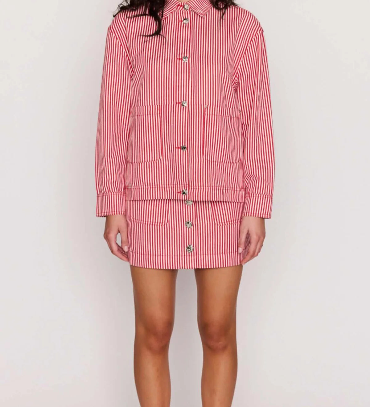 Woman wearing a red and white striped dress on a plain background