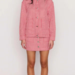 Woman wearing a red and white striped dress on a plain background