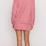 Person wearing a red and white checkered outfit on a plain background