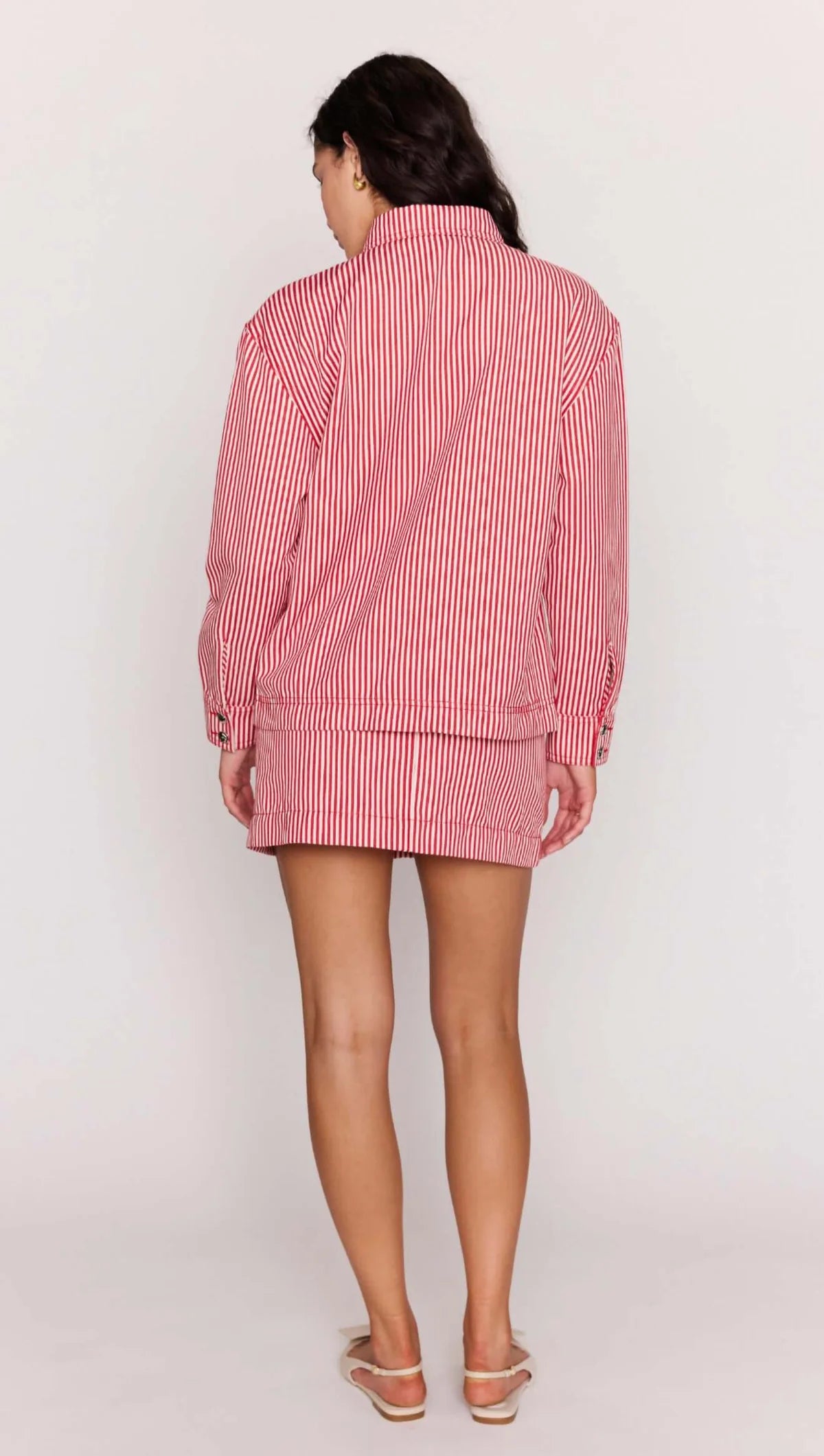 Person wearing a red and white checkered outfit on a plain background