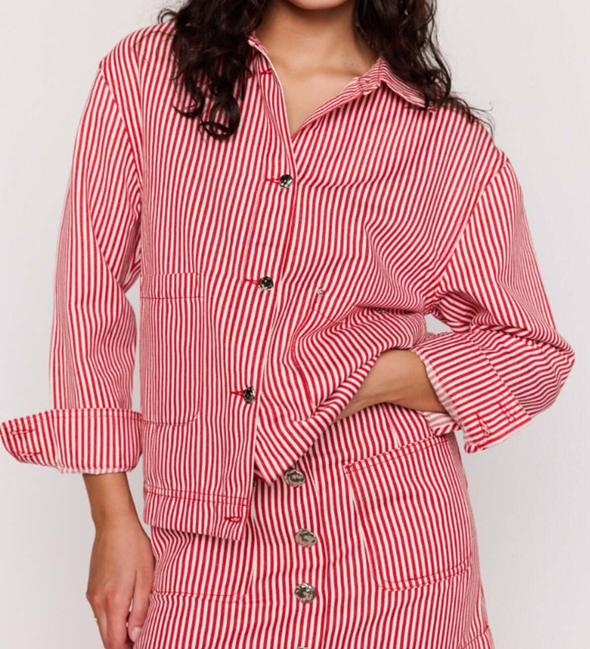 Woman wearing a red and white striped outfit on a plain background