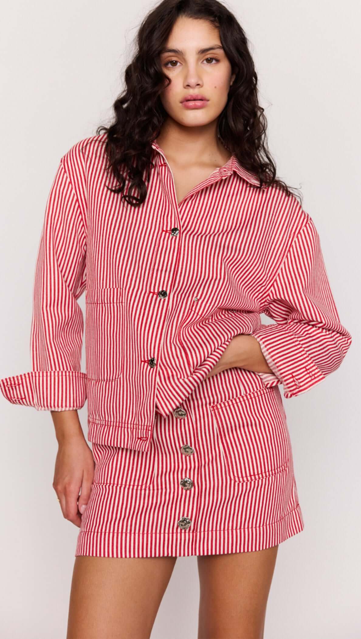 Woman wearing a red and white striped outfit on a plain background
