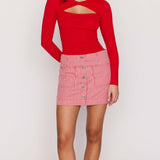 Person wearing a red long-sleeve top and pink checkered skirt on a white background