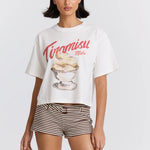 Woman wearing a white t-shirt with a dessert graphic and 'Tiramisu Maku' text on a plain background