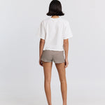 Person wearing a white top and striped shorts on a plain background